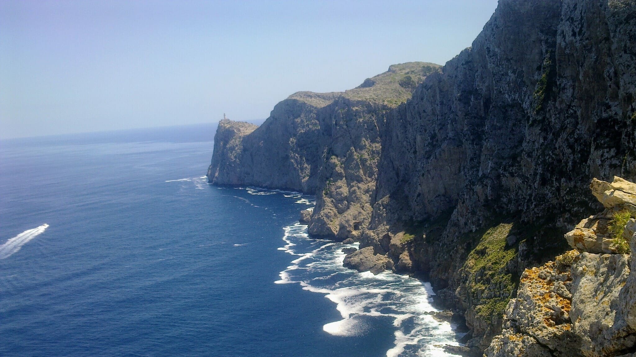 Widok na przylądek Cap de Formentor oraz majacząca latarnia morska Faro de Formentor, widziane z małego, przydrożnego punktu widokowego 